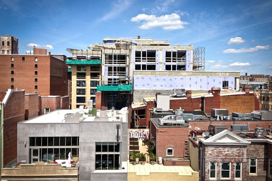 image shows buildings within an urban neighborhood landscape, one building in under construction.