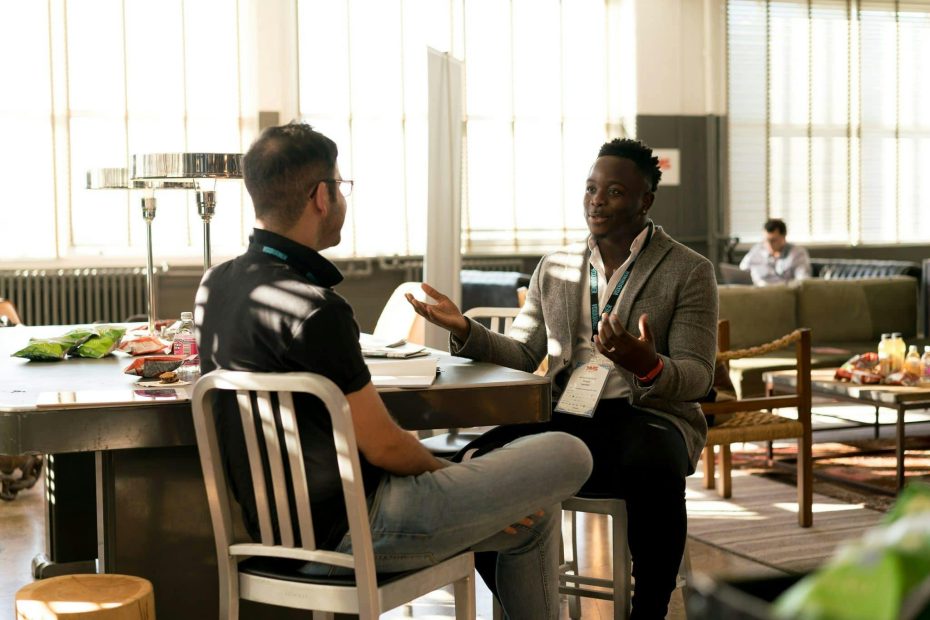 two men in conversation with one another showing postures of curiosity